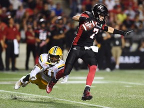 Ottawa Redblacks quarterback Trevor Harris is chased by Edmonton Eskimos defensive end Odell Willis during CFL action in Ottawa on Aug.10, 2017. (THE CANADIAN PRESS/Sean Kilpatrick)