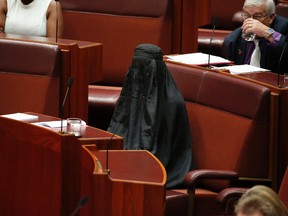 Senator Pauline Hanson wears a burqa during question time in the Senate chamber at Parliament House in Canberra, Australia, Thursday, Aug. 17, 2017. Hanson, leader of the anti-Muslim, anti-immigration One Nation minor party, sat wearing the black head-to-ankle garment for more than 10 minutes before taking it off as she rose to explain that she wanted such outfits banned on national security grounds.(Jed Cooper/Australian Broadcasting Corp. via AP)