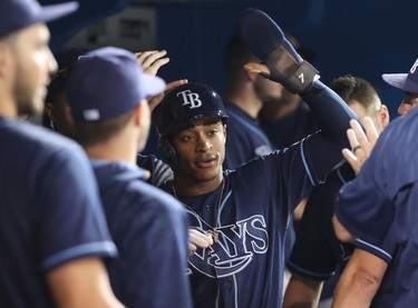 Mallex Smith #0 of the Tampa Bay Rays is congratulated by teammates in the dugout after scoring a run on a bases-loaded walk in the seventh inning during MLB game action against the Toronto Blue Jays at Rogers Centre on August 16, 2017 in Toronto, Canada. (Tom Szczerbowski/Getty Images)
