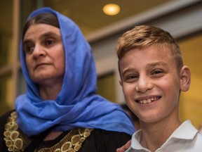 Nofa Mihlo Rafo, left, is reunited with her 12-year-old son Emad Mishko Tamo at Winnipeg's James Armstrong Richardson International Airport Thursday August 17, 2017. Emad Mishko Tamo was rescued by Iraqi forces in July, after being held captive by ISIL for the past three years. THE CANADIAN PRESS/David Lipnowsk