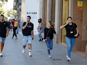 People run down a street in Barcelona, Spain, on Thursday, Aug. 17, 2017. Police say a white van jumped the sidewalk in the city's historic Las Ramblas district, killing at least 13 people and injuring more than 50. (Manu Fernandez/AP Photo)
