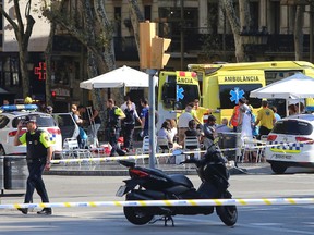 Injured people are treated in Barcelona, Spain, Thursday, Aug. 17, 2017 after a white van jumped the sidewalk in the historic Las Ramblas district. (AP Photo/Oriol Duran)