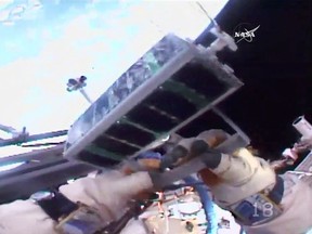 In this image made from video provided by NASA, Russian cosmonaut Sergei Ryazansky holds a mini satellite before launching it by hand from the International Space Station on Thursday, Aug. 17, 2017. (NASA via AP)
