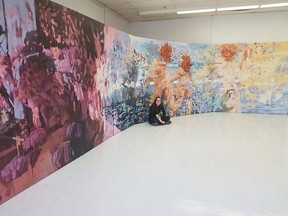 Queen's University fine arts graduate Jessica Peterson sits with her painting, "Overripe", which won the BMO First Art! award for Ontario this year. (Submitted photo)