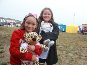 Madi Patriquim,left, and her sister Cali hug the bears they made at Ruelland’s Stuffin’ Bears at the Iron Horse Festival. Rain prevented big crowds from turning out to the annual festival on Thursday afternoon.