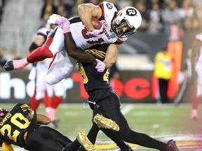 Ottawa Redblacks' Patrick Lavoie is tackled by Hamilton Tiger-Cats linebacker Larry Dean during CFL action in Hamilton on Oct. 14, 2016. (THE CANADIAN PRESS/Peter Power)