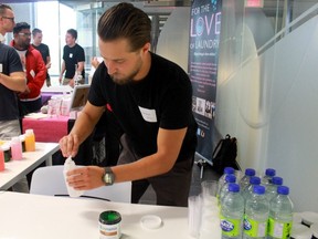 Ryan Bauer mixes Dynamix with water for people to taste during demonstration day for participants in a Western University program for entrepreneurs. Dynamix, created by Erik Lapointe, Michael Palumbo and Bauer is a powdered drink that emulsifies cannabis and essential oils and gets rid of the foul taste associated with them. (Shalu Mehta/The London Free Press)