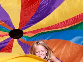 Bella Jenkins, 7, crawls out of a parachute as campers play at King?s University College?s Inter-Faith Peace Camp before a visit to the London Muslim Mosque on Wednesday. (Shalu Mehta/The London Free Press)