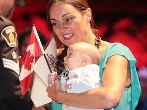 Nathalie Chaloin from France is all smiles with her three-month-old baby Marcus Darling after becoming a Canadian citizen at the community citizenship ceremony at Science North in Sudbury, Ont. on Thursday August 17, 2017. Gino Donato/Sudbury Star/Postmedia Network