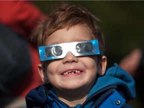 A young astronomer uses protective glasses to catch a glimpse of a solar eclipse on March 20, 2015 in Berlin. A partial eclipse of varying degrees is visible, depending on weather conditions, across most of Europe, northern Africa, northwest Asia and the Middle East, before finishing its show close to the North Pole. AFP PHOTO / STEFFI LOOSSTEFFI LOOS/AFP/Getty Images