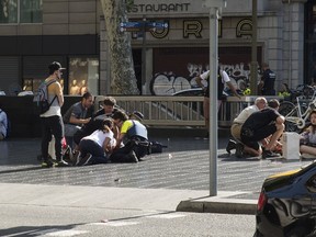 People help injured persons after a van ploughed into the crowd, killing at least 13 people and injuring around 100 others on the Rambla in Barcelona on August 17, 2017.
A driver deliberately rammed a van into a crowd on Barcelona's most popular street on August 17, 2017 killing at least 13 people before fleeing to a nearby bar, police said.
Officers in Spain's second-largest city said the ramming on Las Ramblas was a "terrorist attack". The driver of a van that mowed into a packed street in Barcelona is still on the run, Spanish police said. / AFP PHOTO / NICOLAS CARVALHO OCHOA / ALTERNATIVE CROP NICOLAS CARVALHO OCHOA/AFP/Getty Images