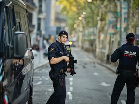 Armed police officers patrol a deserted street in Las Ramblas, in Barcelona, Spain, Friday, Aug. 18, 2017. A white van jumped up onto a sidewalk and sped down a pedestrian zone Thursday in Barcelona's historic Las Ramblas district, swerving from side to side as it plowed into tourists and residents. Police said 13 people were killed and more than 50 wounded in what they called a terror attack.(AP Photo/Manu Fernandez)