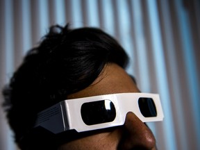 A man models a pair of eclipse viewing glasses for a photograph, in Toronto on Thursday, August 17, 2017. Demand seems to be eclipsing supply for the specialized glasses eclipse viewers will use to observe Monday's solar eclipse event. (Giordano Ciampini/THE CANADIAN PRESS)