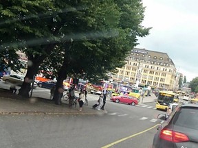 A yellow ambulance (behind red car) is seen on the corner of Turku Market Square on Friday, Aug. 18, 2017. Police in Finland say they have shot a man in the leg after he was suspected of stabbing several people in the western city of Turku. (Lehtikuva via AP)