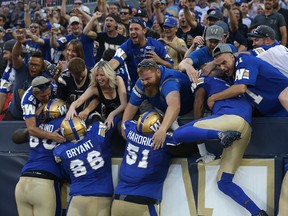 Winnipeg Blue Bomber players jump into the north end zone stands after a touchdown run from quarterback Dan LeFevour against the Edmonton Eskimos during CFL action in Winnipeg on Thurs., Aug. 17, 2017. Kevin King/Winnipeg Sun