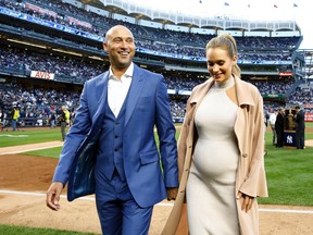 In this May 14, 2017, file pool photo, retired New York Yankees shortstop Derek Jeter, left, and his wife Hannah walk off the field following a pregame ceremony retiring his No. 2 in Monument Park at Yankee Stadium in New York. The couple have welcomed a baby girl, Bella Raine Jeter, who was born Thursday, according to a tweet Friday, Aug. 18, 2017, from The Players’ Tribune, the media platform founded by Jeter. (AP Photo/Kathy Willens, Pool)