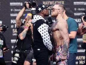 Floyd Mayweather Jr., left, and Conor McGregor, of Ireland, face each other for photos during a news conference at Barclays Center in New York. (AP Photo/Frank Franklin II, File)