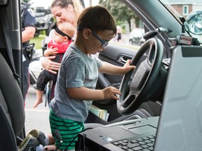 Taylor Bertelink/The Intelligencer
Two-year-old Benjamin Perkes climbs into one of the Belleville Police SUVs filled with gadgets and buttons during the open house event on Friday.