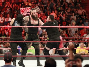 World Wrestling Entertainment superstar Braun Strowman prepares to choke slam Roman Reigns, left, and Samoa Joe during a recent episode of Raw. All three face Brock Lesnar for his WWE Universal Championship on in a Fatal Fourway match Sunday at SummerSlam in Brooklyn, N.Y. (World Wrestling Entertainment photo)