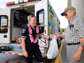 Luke Hendry/The Intelligencer
Belleville's Vein Dolph donates food for Gleaners Food Bank via Hastings-Quinte paramedic Carole Goodall outside the city's Metro store Friday in Belleville. August is the month of highest demand at Gleaners; the paramedics' food drive continues Sunday.