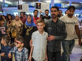 12-year-old Emad Mishko Tamo, centre, stands with uncle Hadji Tamo and his mother Nofa Mihlo Rafo as he's reunited with friends and family at Winnipeg's James Armstrong Richardson International Airport, early Thursday, August 17, 2017. THE CANADIAN PRESS/David Lipnowski