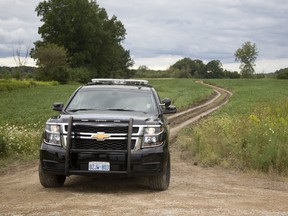 A First Nations police vehicle guards the entrance to a farm field where human remains were found west of Bodkin Road on Oneida Nation of the Thames reserve, southwest of London, Friday. Investigators haven’t said whether the discovery is linked to the June disappearance of Douglas Hill, 48, of Six Nations of the Grand River near Brantford. His body hasn’t been found, but three people have been charged in his death. (MIKE HENSEN, The London Free Press)