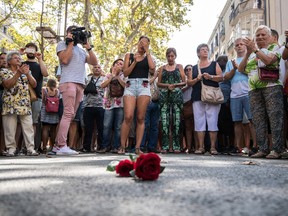 People gather around roses laid on the ground on Las Ramblas after a one minute's silence for the victims of yesterday's terrorist attack, on August 18, 2017 in Barcelona, Spain. (Photo by Carl Court/Getty Images)
