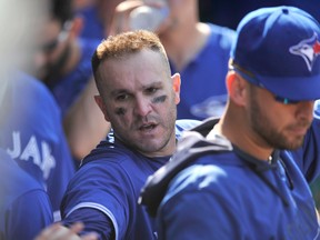 Toronto Blue Jays' Miguel Montero celebrates with teammates in the dugout after scoring on a Ryan Goins two-RBI single during MLB action against the Chicago Cubs on Aug. 18, 2017. (AP Photo/Paul Beaty)