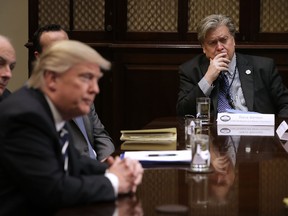 White House Chief Strategist Steve Bannon (R) listens to U.S. President Donald Trump at the beginning of a meeting with government cyber security experts in the Roosevelt Room at the White House January 31, 2017 in Washington, DC. (Photo by Chip Somodevilla/Getty Images)