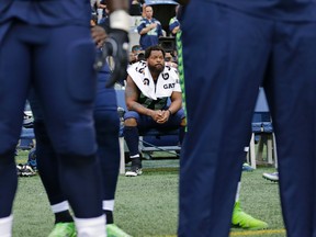 Seattle Seahawks defensive end Michael Bennett sits on the bench during the singing of the national anthem before an NFL football preseason game against the Minnesota Vikings, Friday, Aug. 18, 2017, in Seattle. (AP Photo/Stephen Brashear)