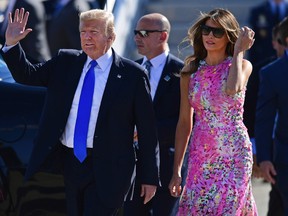 U.S. President Donald Trump waves as he walks with first lady Melania Trump at the Youngstown-Warren Regional Airport in Vienna, Ohio, on July 25, 2017. (David Dermer/The Vindicator via AP)