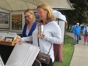 Karlene Shaw, right, and Anita Ollett of Bright's Grove check out an artist's booth Saturday at Artzscape by the Bay at Centennial Park in Sarnia, Ont. The fundraiser for the Pathways Health Centre for Children continued Sunday.