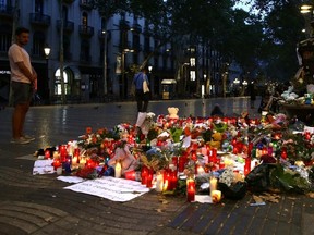 A man looks at flags, messages and candles placed after van attack that killed at least 13, in Barcelona, Spain, on Saturday, Aug. 19, 2017. (Manu Fernandez/AP Photo)