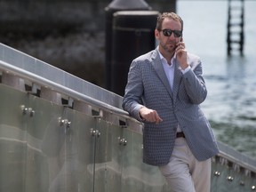 Liberal Leader Justin Trudeau's chief advisor Gerald Butts speaks on his phone as Trudeau holds a news conference in North Vancouver, B.C., on Friday May 29, 2015. THE CANADIAN PRESS/Darryl Dyck