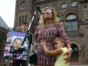 Tina Faibish, whose son Jonathan Khan was fatally shot, holds her granddaughter, Jaylah, during a rally to raise awareness on gun violence in Toronto at Queen's Park on Saturday August 19, 2017.. (Dave Abel/Toronto Sun)