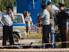 Police officers stand by the body of a man who was killed after an alleged stabbing attack, in the Siberian city of Surgut, Russia, Saturday, Aug. 19, 2017. (Irina Shvets/Siapress.ru via AP)