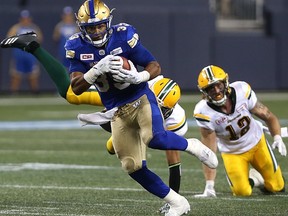 Winnipeg Blue Bombers running back Andrew Harris sheds a pair of Edmonton Eskimos tacklers during CFL action in Winnipeg on Thurs., Aug. 17, 2017.