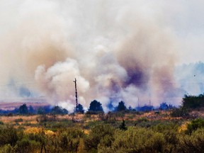 A fire burns southwest of the Madras Municipal Airport in Madras, Ore., on Saturday. Aug. 19, 2017 after a fatal plane crash in Willow Creek Canyon. The area is considered a prime viewing area for Monday's solar eclipse. (Rhianna Gelhart/The Register-Guard via AP)