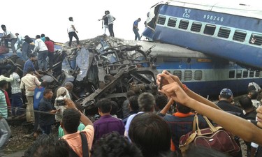Railway police and local volunteers look for survivors in the upturned coaches of the Kalinga-Utkal Express after an accident near Khatauli, in the northern Indian state of Uttar Pradesh, Saturday, Aug. 19, 2017. (AP Photo)
