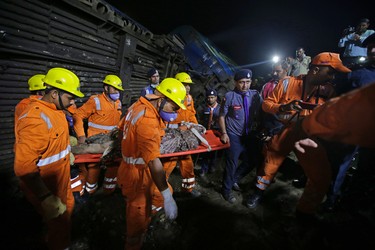 Rescuers carry the body of a victim recovered from upturned coaches of the Kalinga-Utkal Express after an accident near Khatauli, in the northern Indian state of Uttar Pradesh, India, Sunday, Aug. 20, 2017. (AP Photo/Altaf Qadri)