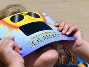 A child uses solar eclipse viewing glasses to look at the sun during the Solar Eclipse Festival at the California Science Center in Los Angeles, California on August 19, 2017, two days before The Solar Eclipse on Monday