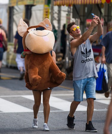 Frank Laconis takes a selfie with his girlfriend Cristina Sa carrying a giant stuffed dog he won for her at the annual CNE in Toronto, Ont. on Sunday August 20, 2017. Laconis won the dog with the shooting game with the paper target.  Ernest Doroszuk/Toronto Sun/Postmedia Network
