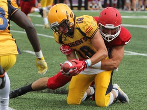 Queen's Golden Gaels’ Matteo Del Brocco is taken down by Vincent Dethier of the McGill Redmen during the second half of exhibition university football play at Richardson Stadium on Saturday. Queen's defeated McGill 38-24. (Steph Crosier/The Whig-Standard)