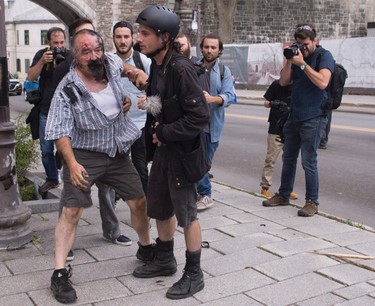 Eric Roy gets help after he was attacked by a group of people during an anti-racism demonstration, in Quebec City on Sunday, Aug. 20, 2017. THE CANADIAN PRESS/Jacques Boissinot