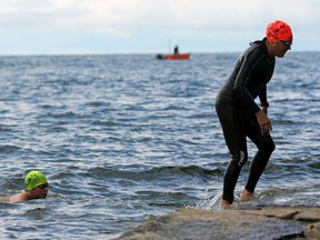 Participants exit Lake Ontario at the first Swim for Kids fundraising event at Richardson Beach on Saturday. (Steph Crosier/The Whig-Standard)