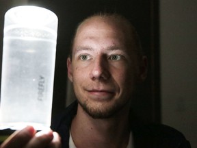 Mitch Churchill demonstrates his Firefly Outdoors Lantern and Water Bottle last week. The drinking container,which doubles as a lantern, is available at area retailers. (Gino Donato/Sudbury Star)