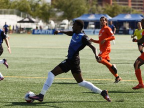FC Edmonton's Tomi Ameobi (18) carries the ball past Puerto Rico FC defenders during an NASL soccer game at Clarke Stadium in Edmonton, Alberta on Aug. 20, 2017.