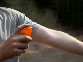 A man applying bug spray. (TinkerJulie/iStock/Getty Images Plus)