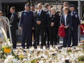 From the middle left, the Chief of Turku Police Tapio Huttunen, Finland's Prime Minister Juha Sipilae and Finnish parliament member Annika Saarikko stand next to the makeshift memorial at the Turku Market Square on August 21, 2017. (Outroni Lehti/AFP/Getty Images)