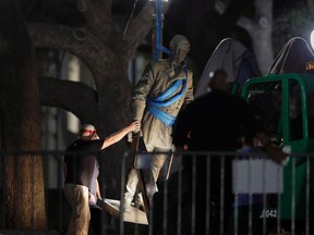 A statue of Confederate Gen. Robert E. Lee is removed from the University of Texas campus, early Monday morning, Aug. 21, 2017, in Austin, Texas. (AP Photo/Eric Gay)